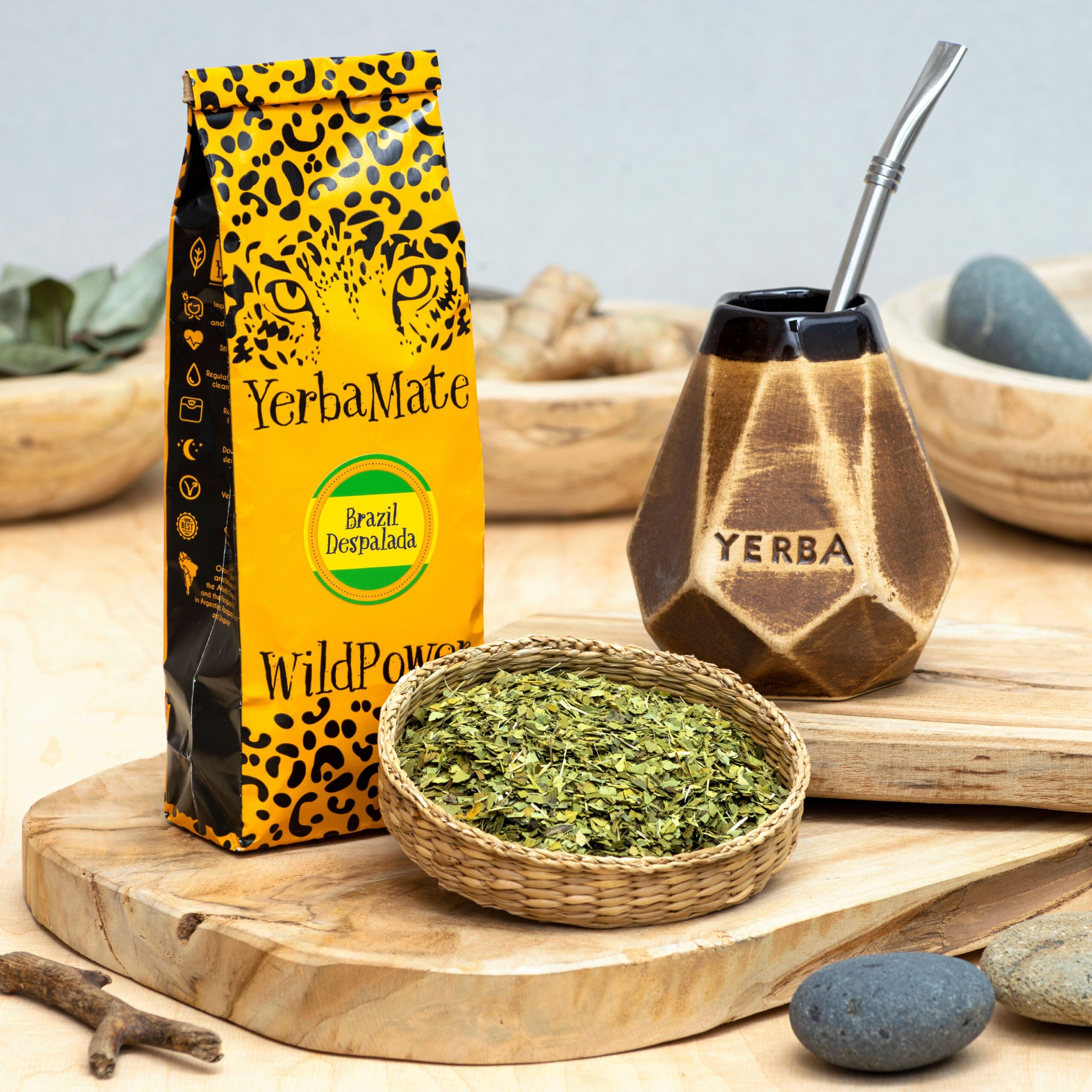 Żółto-czarne opakowanie YerbaMate WildPower, naczynko z napisem „Yerba”, metalowa bombilla i koszyk z liśćmi.