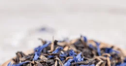 Suszona herbata earl grey w drewnianej misce na jasnym tle