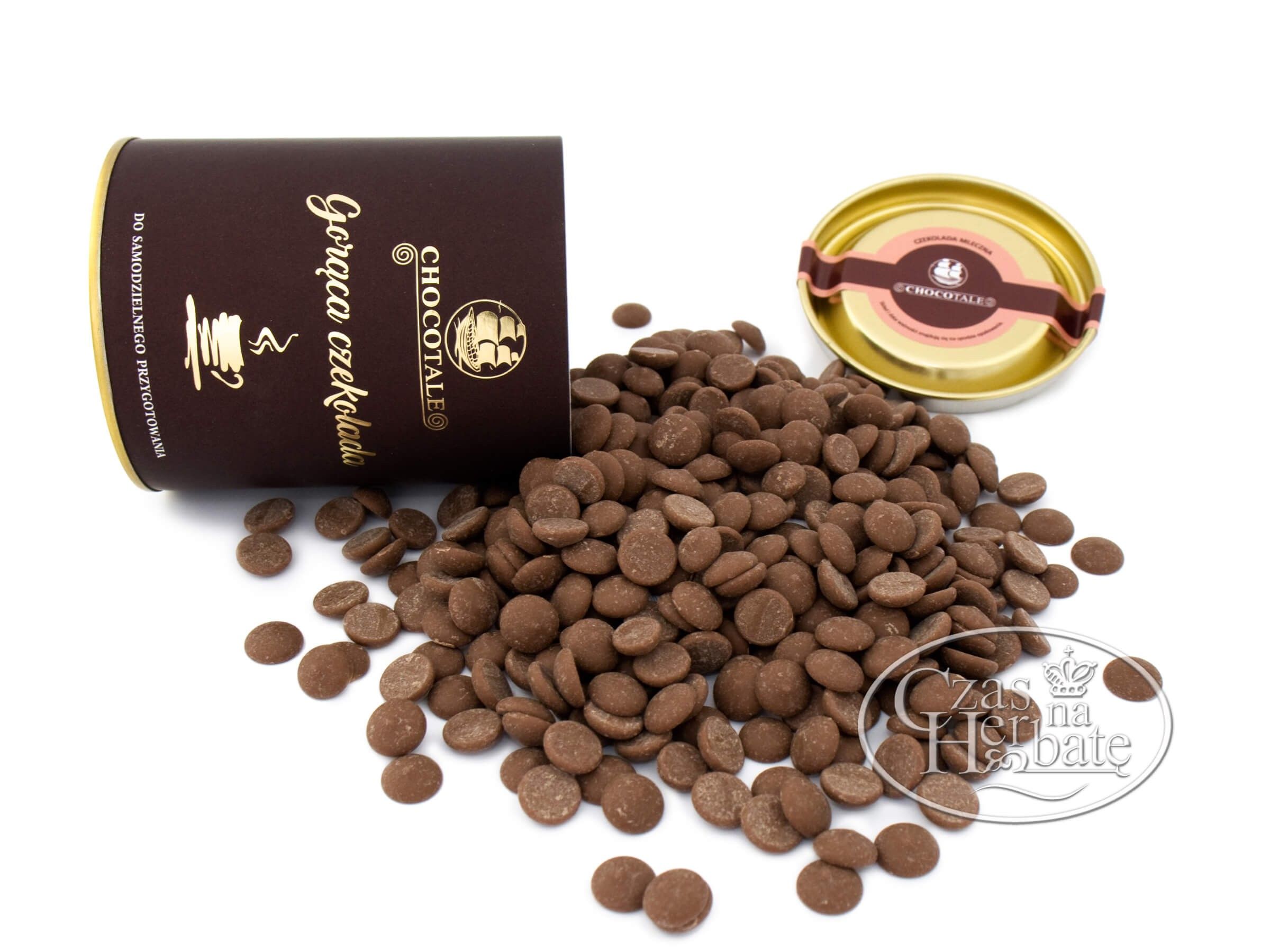 Przewrócona brązowa puszka, obok złote wieczko i wysypane krążki czekolady