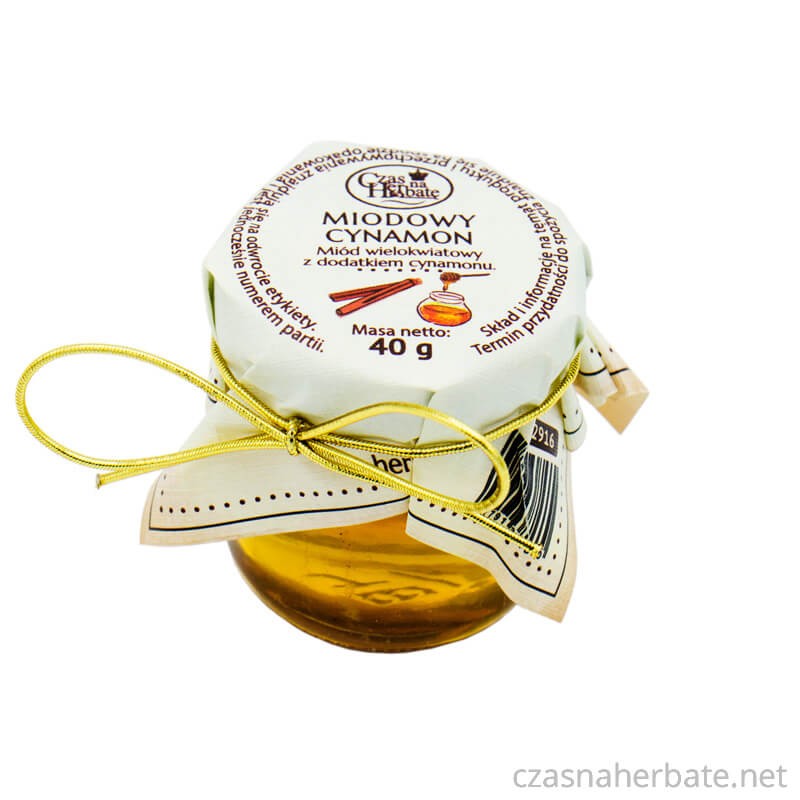 Słoiczek miodowego cynamonu z etykietą obwiązaną złotą gumką na wieczku