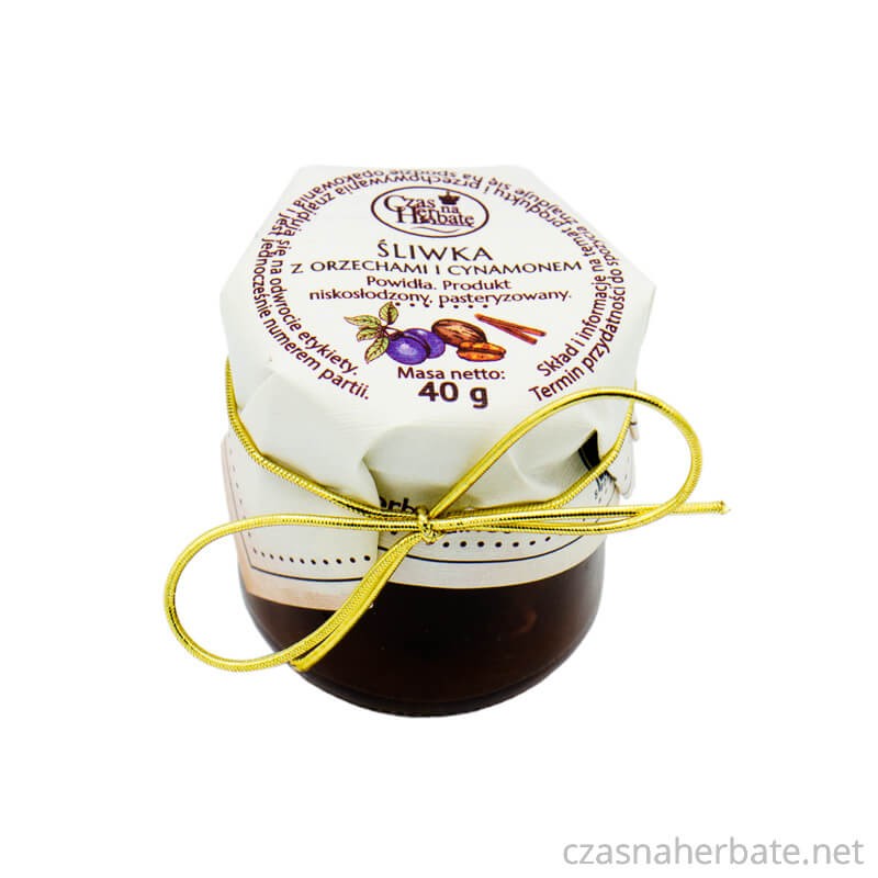 Słoiczek śliwki z orzechami i cynamonem z etykietą obwiązaną złotą gumką na wieczku