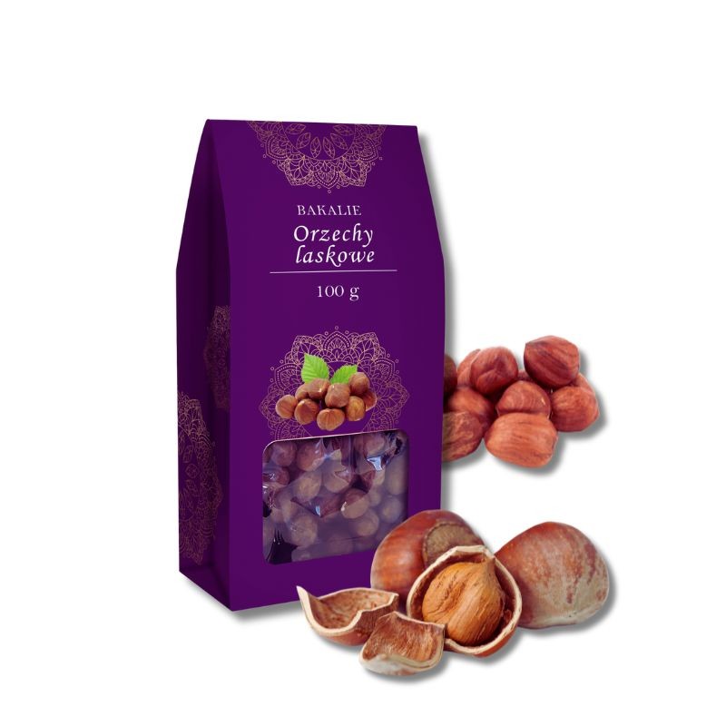 Widok z boku na fioletowe opakowanie z kwadratowym okienkiem, obok niego kilka orzechów laskowych