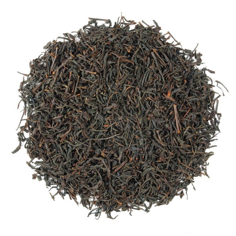 Ułożone w koło liście czarnej herbaty na białym tle