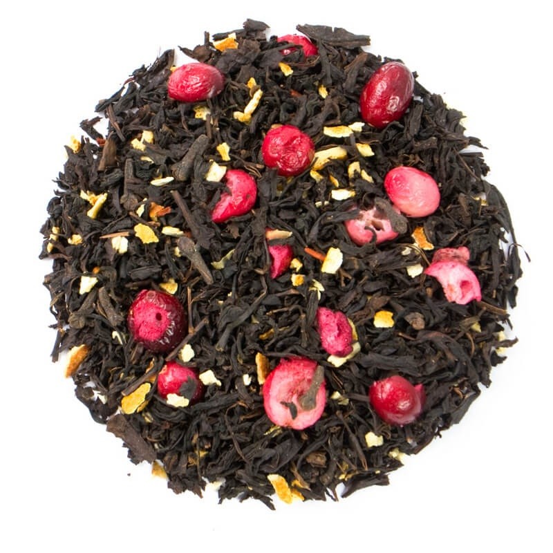 Liście czarnej herbaty z dodatkiem skórki pomarańczowej, żurawiny i goździków na białym tle