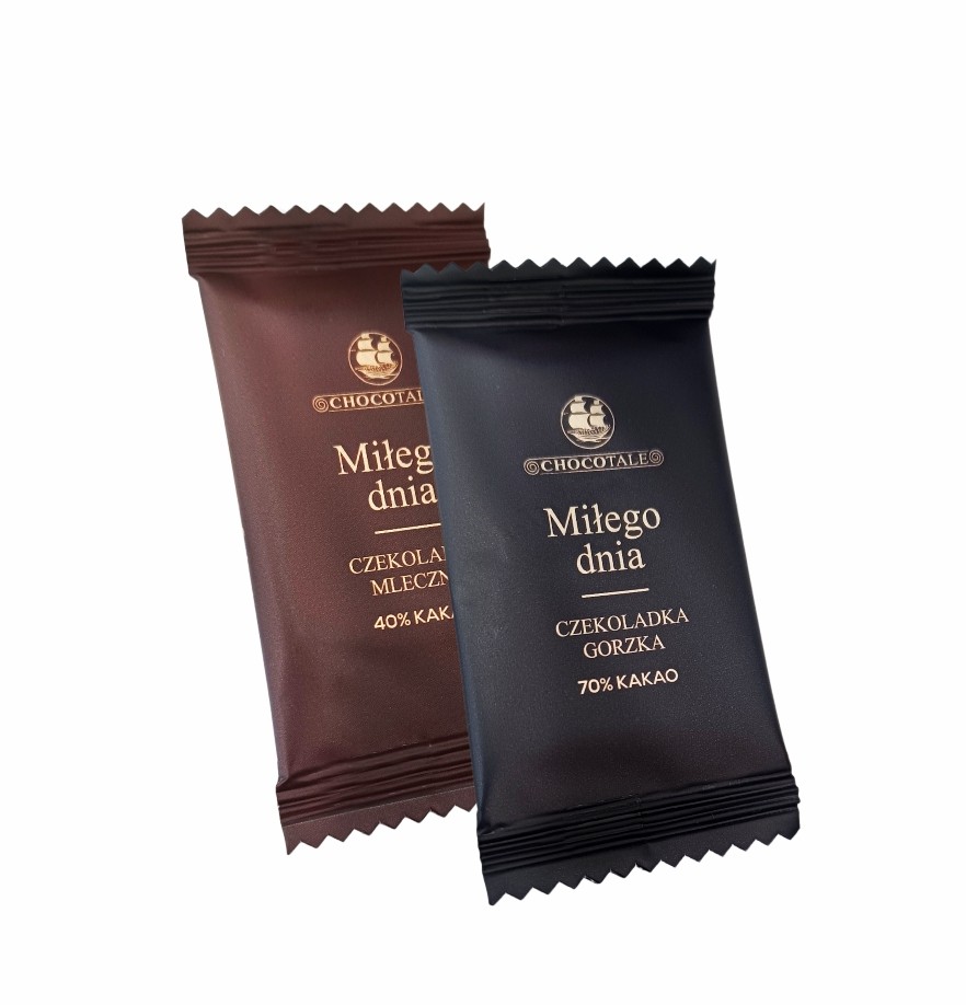 Widok z boku na czekoladkę mleczną w brązowym opakowaniu z napisem "Miłego dnia" i "40% kakao" oraz na czekoladkę gorzką w czarnym opakowaniu z napisem "Miłego dnia" i "70% kakao"