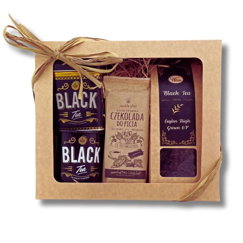 Beżowy karton z kwadratowym okienkiem i wstążką z rafii, w środku puszka z herbatą, kubek, beżowe opakowanie czekolady do picia, kartonik herbaty z czarną etykietą