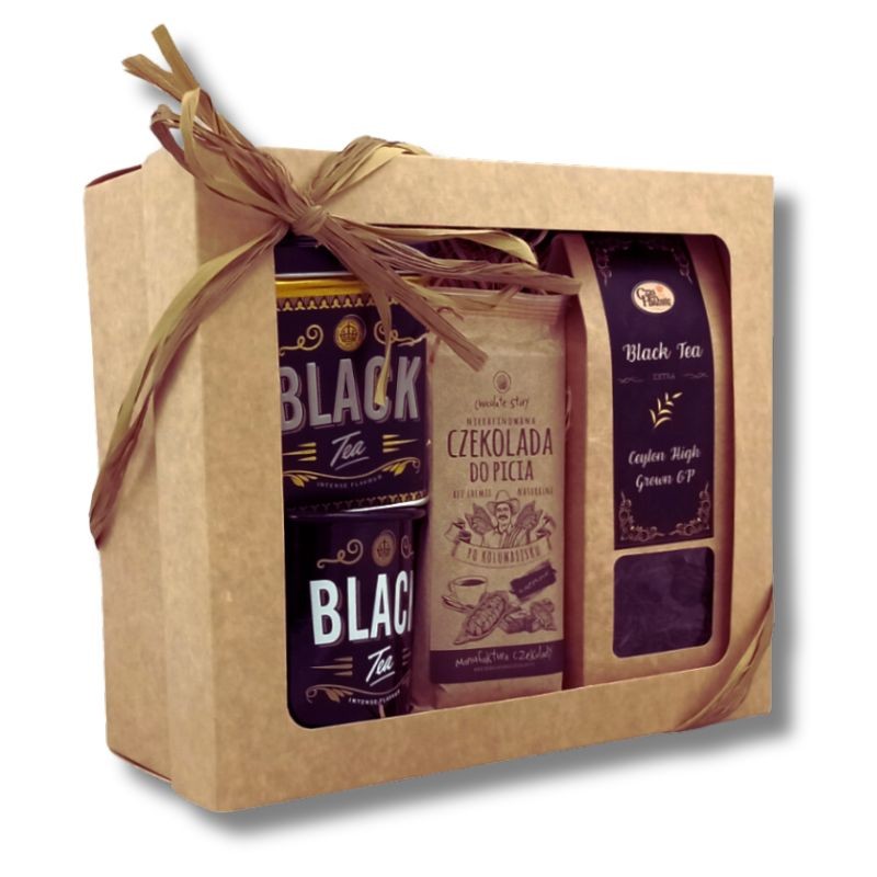 Widok z boku na beżowy karton z kwadratowym okienkiem i wstążką z rafii, w środku puszka z herbatą, kubek, beżowe opakowanie czekolady do picia, kartonik herbaty z czarną etykietą