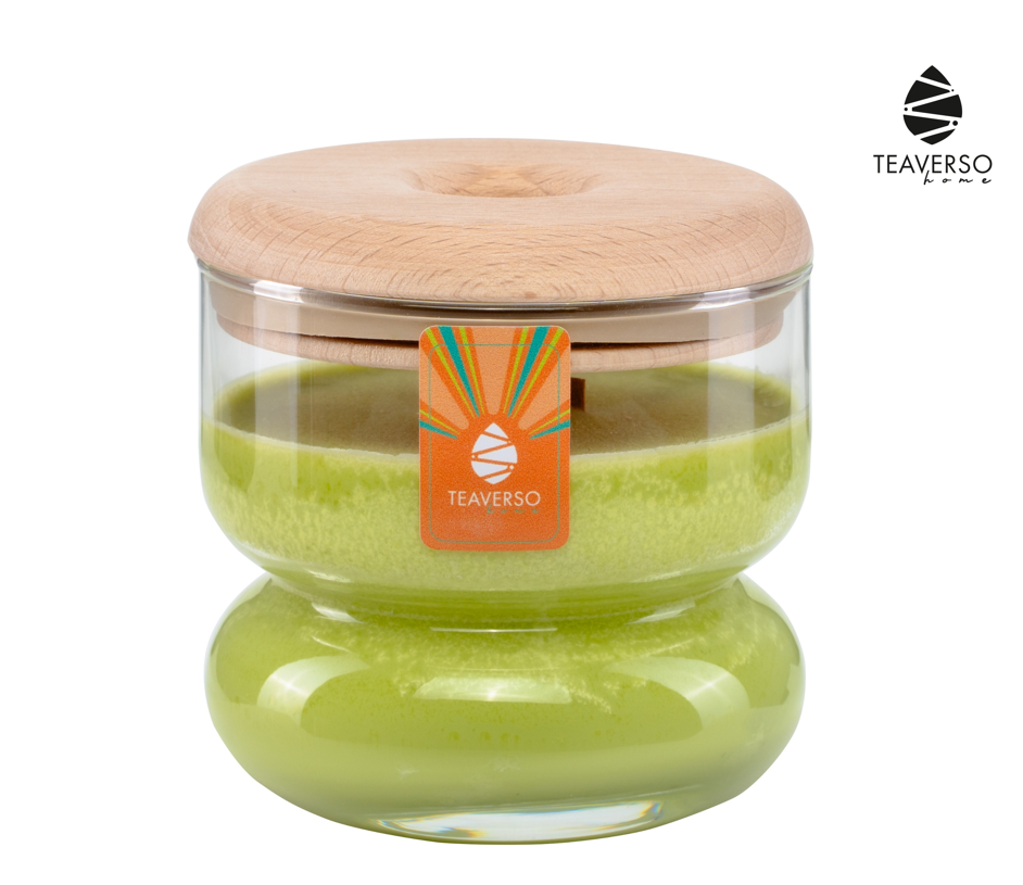 Zielona sojowa świeca zapachowa Teaverso Thalia zielona herbata w okrągłym szklanym słoiku z korkiem i pomarańczową etykietą.