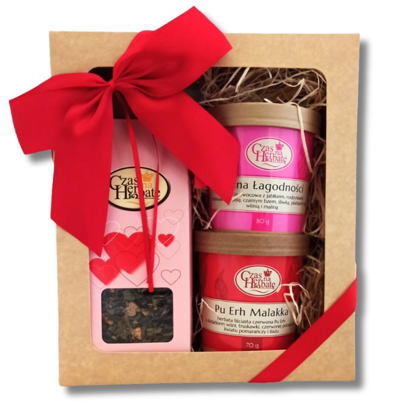 Widok z przodu na zestaw prezentowy z czerwoną kokardą: Kraina Łagodności, Pu Erh Malakka, herbata liściasta, Czas na Herbatę.