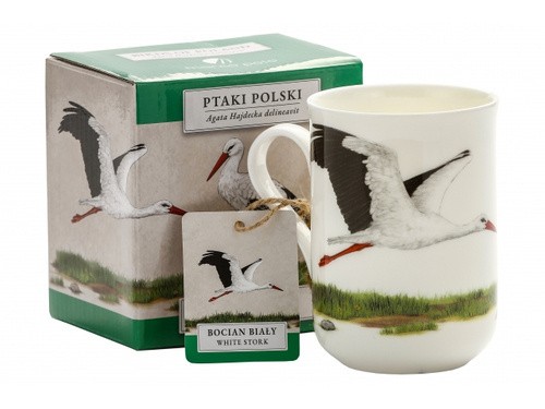 Kubek z ilustracją lecącego bociana białego, obok zielone pudełko z tym samym motywem, napisem "Ptaki Polski".