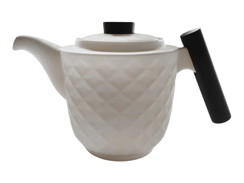 Biały dzbanek z geometrycznym wzorem, pokrywką i drewnianym uchwytem ustawionym pionowo.