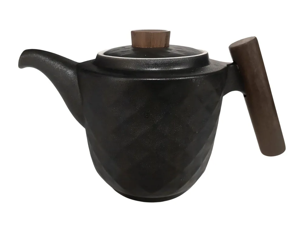 Czarny dzbanek z geometrycznym wzorem, pokrywką i drewnianym uchwytem ustawionym pionowo.