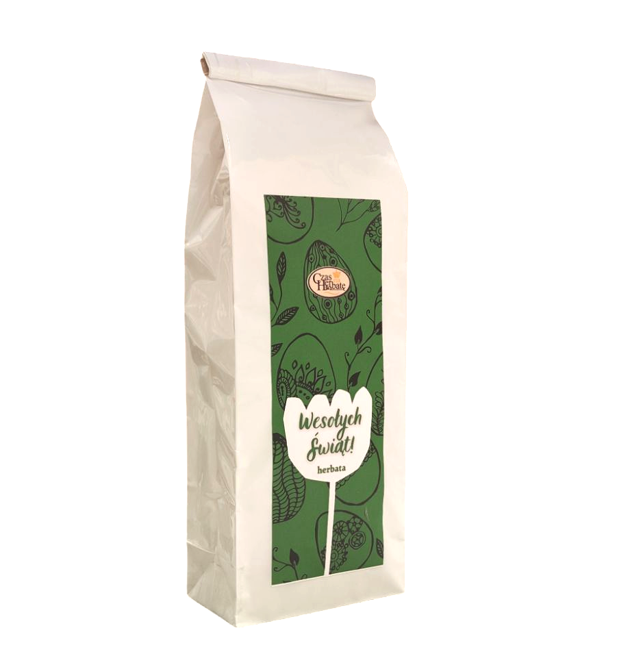 Białe opakowanie herbaty z zieloną etykietą, napisem "Wesołych Świąt!" i wzorem pisanek.