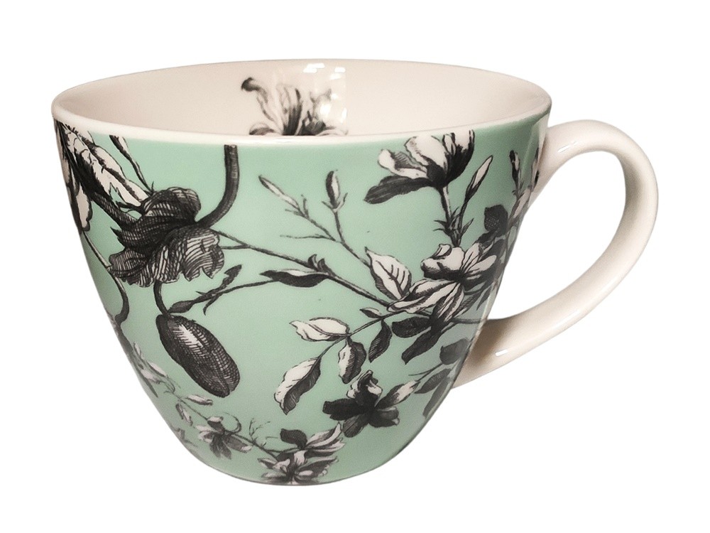 Jasnozielony kubek z czarnym rysunkiem kwiatów i gałązek, o okrągłym kształcie i wygodnym uchwycie.