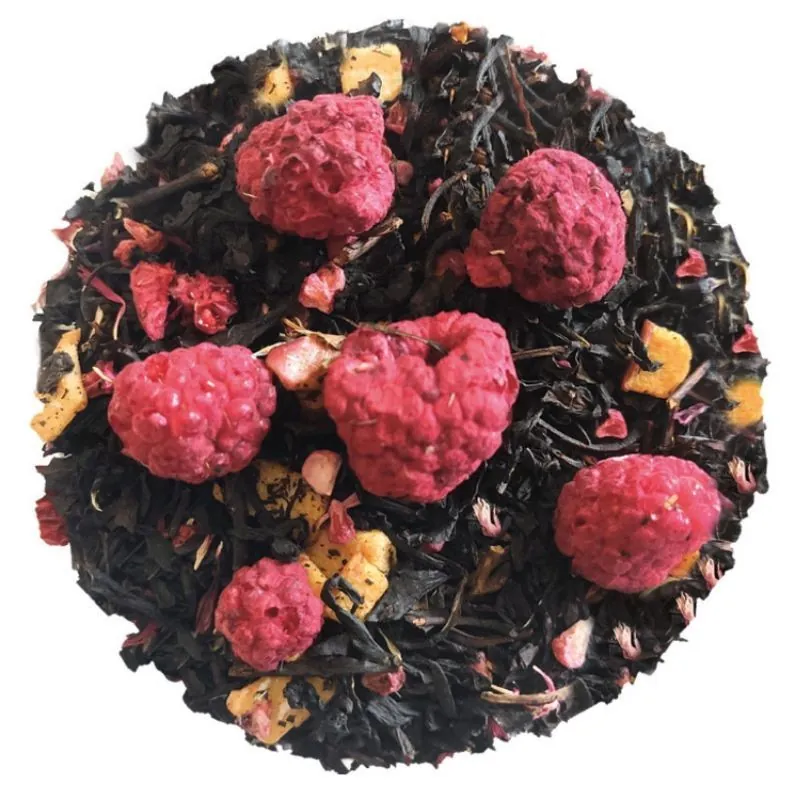 Liście czarnej herbaty z suszonymi malinami i kawałkami owoców, ułożone w okrąg na białym tle.