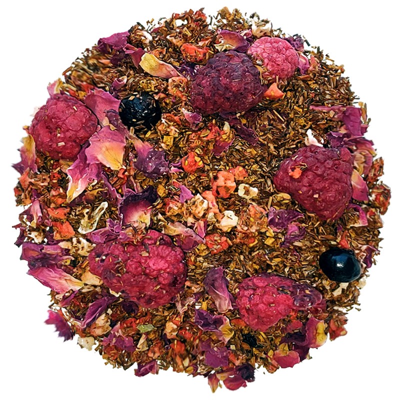Liście herbaty rooibos z malinami, czarnymi jagodami i płatkami róż, ułożone w okrąg na białym tle.