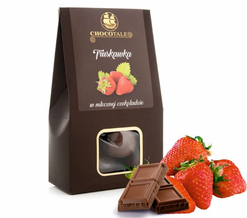 Pudełko Chocotale truskawka w mlecznej czekoladzie, obok tabliczka czekolady i świeże truskawki.