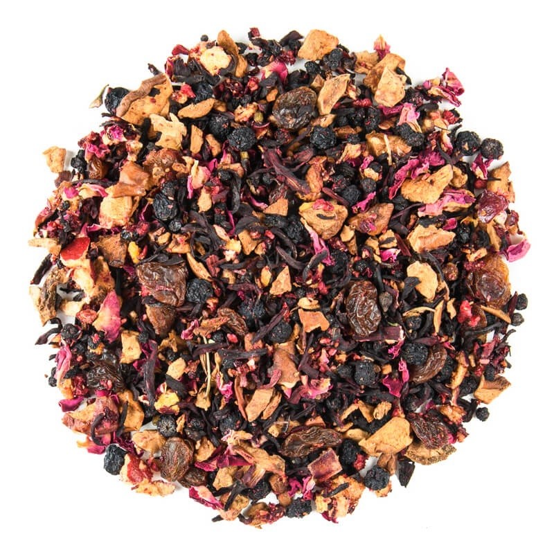 Sypana mieszanka suszonych owoców, hibiskusa, rodzynek, jagód i płatków róży w różnych odcieniach na białym tle.