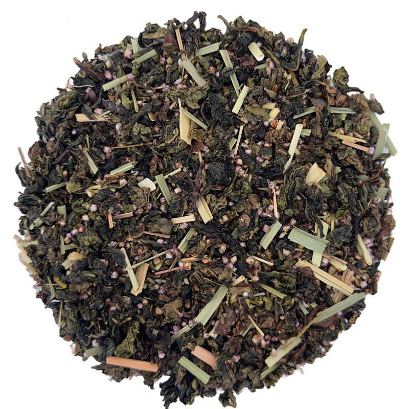 Widok z góry na oolong z trawą cytrynową i dodatkiem wrzosu – charakterystyczne zwijane liście z długimi fragmentami trawy i drobnymi kwiatkami.