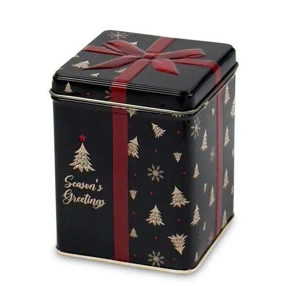 Puszka na herbatę o świątecznym wyglądzie: czarna, metalowa, z nadrukiem choinek, złotym napisem i tłoczonym wzorem kokardy na wieczku.
