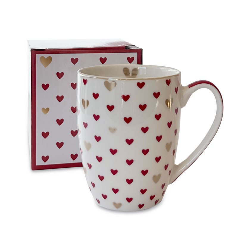 Kubek porcelanowy biały w czerwone i złote serduszka, ustawiony przed dopasowanym opakowaniem z tym samym wzorem.