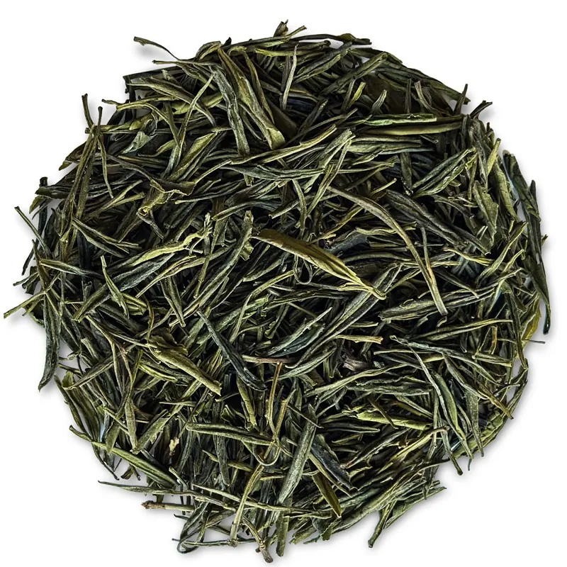 Zielona herbata liściasta, długie, cienkie, jasnozielone i ciemnozielone listki, klasyczna postać wysokogatunkowej zielonej herbaty, widok z góry.
