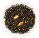 On a white plate is a blend of black tea with pieces of fruit and colorful spices or flower petals.