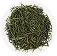 On a white plate is a serving of long leaf green tea.
