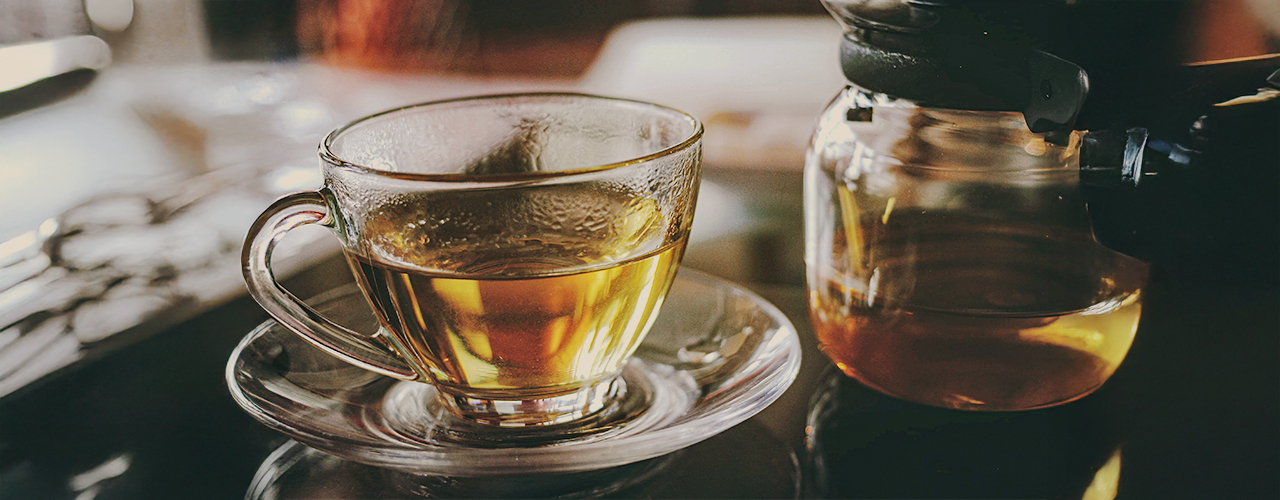 Zielona herbata w filiżance i imbryku